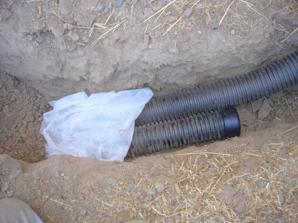 Drainagebuizen en filterdoek in een open sleuf